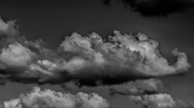 Beyaz bulutların üzerinde karanlık bir gökyüzü, tek renkli.