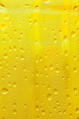 Cam su damlaları, sarı arka plan bira, buğulu arka plan.