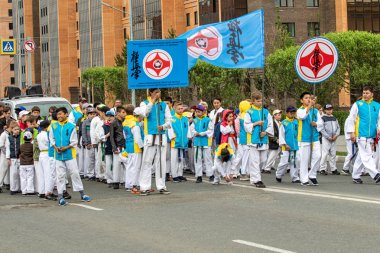 Petropavlovsk, Kazakistan-1 Haziran 2019: Uluslararası Çocuk günü. Şehir sokaklarında okul öğrencileri geçit töreni. Ulusal tatil kıyafetlerinin içinde çocuklar ve ebeveynler. Dans tatil şarkıları.