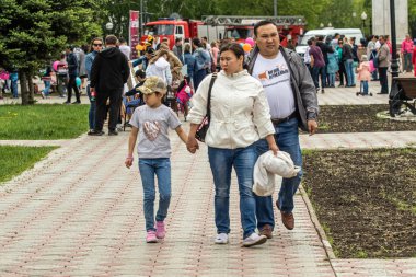 Petropavlovsk, Kazakistan-1 Haziran 2019: Uluslararası Çocuk günü. Şehir sokaklarında okul öğrencileri geçit töreni. Ulusal tatil kıyafetlerinin içinde çocuklar ve ebeveynler. Dans tatil şarkıları.