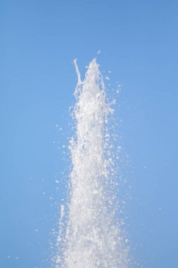 Mavi gökyüzüne karşı Su Çeşmesi sprey. Su sıçramaları odak dışında.