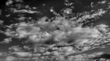 Beyaz bulutların üzerinde karanlık bir gökyüzü, tek renkli.