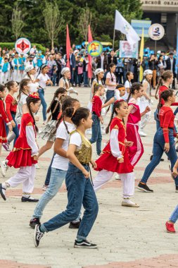 Petropavlovsk, Kazakistan-1 Haziran 2019: Uluslararası Çocuk günü. Şehir sokaklarında okul öğrencileri geçit töreni. Ulusal tatil kıyafetlerinin içinde çocuklar ve ebeveynler. Dans tatil şarkıları.