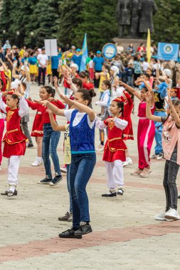 Petropavlovsk, Kazakistan-1 Haziran 2019: Uluslararası Çocuk günü. Şehir sokaklarında okul öğrencileri geçit töreni. Ulusal tatil kıyafetlerinin içinde çocuklar ve ebeveynler. Dans tatil şarkıları.