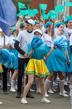 Petropavlovsk, Kazakistan-1 Haziran 2019: Uluslararası Çocuk günü. Şehir sokaklarında okul öğrencileri geçit töreni. Ulusal tatil kıyafetlerinin içinde çocuklar ve ebeveynler. Dans tatil şarkıları.