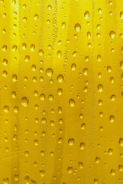 Cam su damlaları, sarı arka plan bira, buğulu arka plan.