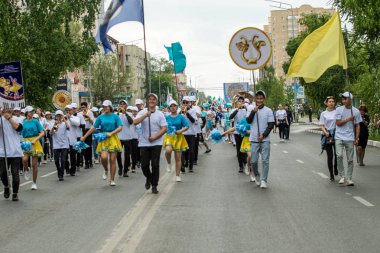 Petropavlovsk, Kazakistan-1 Haziran 2019: Uluslararası Çocuk günü. Şehir sokaklarında okul öğrencileri geçit töreni. Ulusal tatil kıyafetlerinin içinde çocuklar ve ebeveynler. Dans tatil şarkıları.