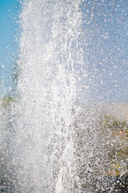 Mavi gökyüzüne karşı Su Çeşmesi sprey. Su sıçramaları odak dışında.