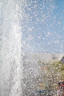 Mavi gökyüzüne karşı Su Çeşmesi sprey. Su sıçramaları odak dışında.