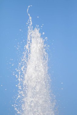 Mavi gökyüzüne karşı Su Çeşmesi sprey. Su sıçramaları odak dışında.