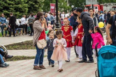 Petropavlovsk, Kazakistan-1 Haziran 2019: Uluslararası Çocuk günü. Şehir sokaklarında okul öğrencileri geçit töreni. Ulusal tatil kıyafetlerinin içinde çocuklar ve ebeveynler. Dans tatil şarkıları.