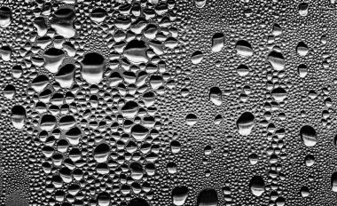 Cam üzerinde yağmur damlaları, siyah-beyaz arka plan, moda cam doku.