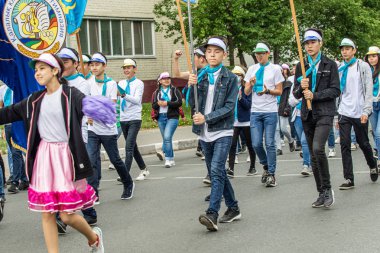 Petropavlovsk, Kazakistan-1 Haziran 2019: Uluslararası Çocuk günü. Şehir sokaklarında okul öğrencileri geçit töreni. Ulusal tatil kıyafetlerinin içinde çocuklar ve ebeveynler. Dans tatil şarkıları.