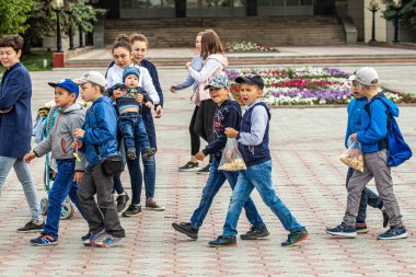 Petropavlovsk, Kazakistan-1 Haziran 2019: Uluslararası Çocuk günü. Şehir sokaklarında okul öğrencileri geçit töreni. Ulusal tatil kıyafetlerinin içinde çocuklar ve ebeveynler. Dans tatil şarkıları.