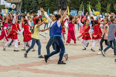 Petropavlovsk, Kazakistan-1 Haziran 2019: Uluslararası Çocuk günü. Şehir sokaklarında okul öğrencileri geçit töreni. Ulusal tatil kıyafetlerinin içinde çocuklar ve ebeveynler. Dans tatil şarkıları.