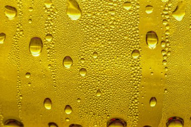 Cam su damlaları, sarı arka plan bira, buğulu arka plan.