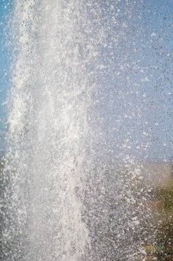 Mavi gökyüzüne karşı Su Çeşmesi sprey. Su sıçramaları odak dışında.