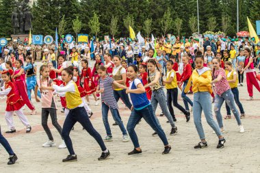 Petropavlovsk, Kazakistan-1 Haziran 2019: Uluslararası Çocuk günü. Şehir sokaklarında okul öğrencileri geçit töreni. Ulusal tatil kıyafetlerinin içinde çocuklar ve ebeveynler. Dans tatil şarkıları.