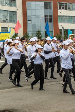 Petropavlovsk, Kazakistan-1 Haziran 2019: Uluslararası Çocuk günü. Şehir sokaklarında okul öğrencileri geçit töreni. Ulusal tatil kıyafetlerinin içinde çocuklar ve ebeveynler. Dans tatil şarkıları.