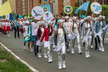 Petropavlovsk, Kazakistan-1 Haziran 2019: Uluslararası Çocuk günü. Şehir sokaklarında okul öğrencileri geçit töreni. Ulusal tatil kıyafetlerinin içinde çocuklar ve ebeveynler. Dans tatil şarkıları.