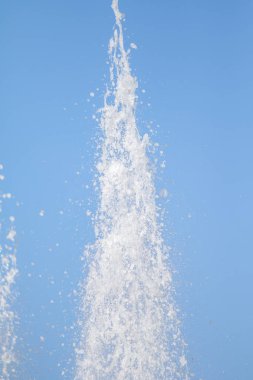Mavi gökyüzüne karşı Su Çeşmesi sprey. Su sıçramaları odak dışında.