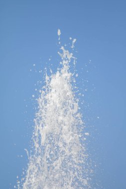 Mavi gökyüzüne karşı Su Çeşmesi sprey. Su sıçramaları odak dışında.