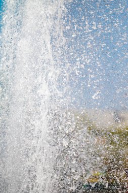 Mavi gökyüzüne karşı Su Çeşmesi sprey. Su sıçramaları odak dışında.