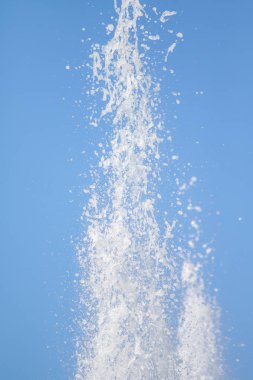 Mavi gökyüzüne karşı Su Çeşmesi sprey. Su sıçramaları odak dışında.