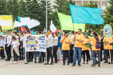 Petropavlovsk, Kazakistan-1 Haziran 2019: Uluslararası Çocuk günü. Şehir sokaklarında okul öğrencileri geçit töreni. Ulusal tatil kıyafetlerinin içinde çocuklar ve ebeveynler. Dans tatil şarkıları.