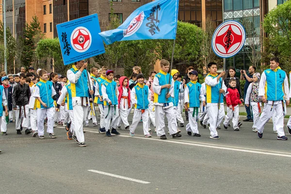 Petropavlovsk, Kazakistan-1 Haziran 2019: Uluslararası Çocuk günü. Şehir sokaklarında okul öğrencileri geçit töreni. Ulusal tatil kıyafetlerinin içinde çocuklar ve ebeveynler. Dans tatil şarkıları.