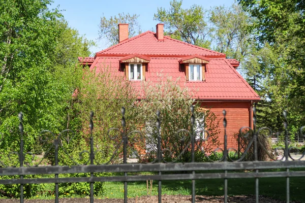 Cihlový Dům Kovovým Plotem Pramen Zelených Stromů — Stock fotografie