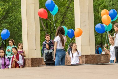 Petropavlovsk, Kazakistan-1 Haziran 2019: Uluslararası Çocuk günü. Şehir sokaklarında okul öğrencileri geçit töreni. Ulusal tatil kıyafetlerinin içinde çocuklar ve ebeveynler. Dans tatil şarkıları.