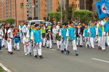 Petropavlovsk, Kazakistan-1 Haziran 2019: Uluslararası Çocuk günü. Şehir sokaklarında okul öğrencileri geçit töreni. Ulusal tatil kıyafetlerinin içinde çocuklar ve ebeveynler. Dans tatil şarkıları.