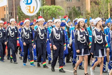 Petropavlovsk, Kazakistan-1 Haziran 2019: Uluslararası Çocuk günü. Şehir sokaklarında okul öğrencileri geçit töreni. Ulusal tatil kıyafetlerinin içinde çocuklar ve ebeveynler. Dans tatil şarkıları.