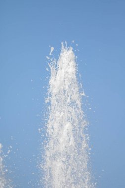Mavi gökyüzüne karşı Su Çeşmesi sprey. Su sıçramaları odak dışında.