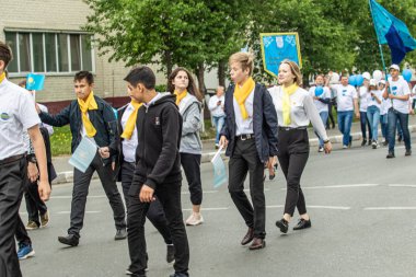 Petropavlovsk, Kazakistan-1 Haziran 2019: Uluslararası Çocuk günü. Şehir sokaklarında okul öğrencileri geçit töreni. Ulusal tatil kıyafetlerinin içinde çocuklar ve ebeveynler. Dans tatil şarkıları.