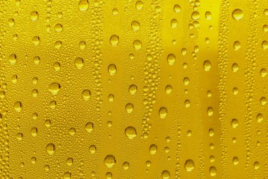 Cam su damlaları, sarı arka plan bira, buğulu arka plan.