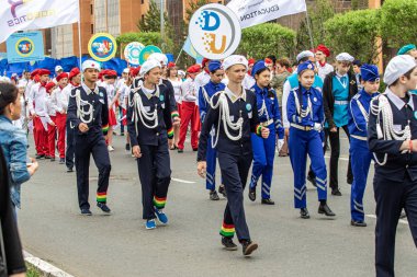 Petropavlovsk, Kazakistan-1 Haziran 2019: Uluslararası Çocuk günü. Şehir sokaklarında okul öğrencileri geçit töreni. Ulusal tatil kıyafetlerinin içinde çocuklar ve ebeveynler. Dans tatil şarkıları.