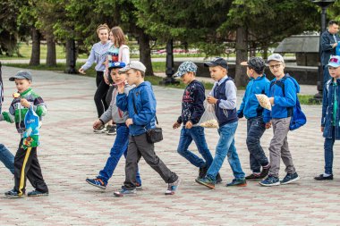Petropavlovsk, Kazakistan-1 Haziran 2019: Uluslararası Çocuk günü. Şehir sokaklarında okul öğrencileri geçit töreni. Ulusal tatil kıyafetlerinin içinde çocuklar ve ebeveynler. Dans tatil şarkıları.