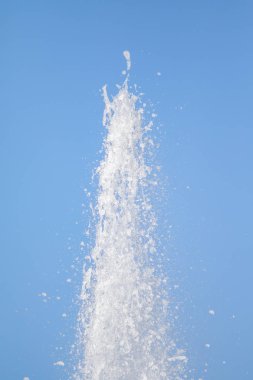 Mavi gökyüzüne karşı Su Çeşmesi sprey. Su sıçramaları odak dışında.