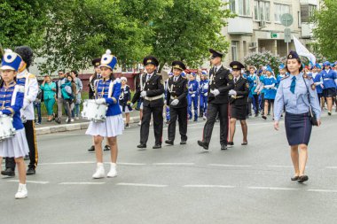 Petropavlovsk, Kazakistan-1 Haziran 2019: Uluslararası Çocuk günü. Şehir sokaklarında okul öğrencileri geçit töreni. Ulusal tatil kıyafetlerinin içinde çocuklar ve ebeveynler. Dans tatil şarkıları.