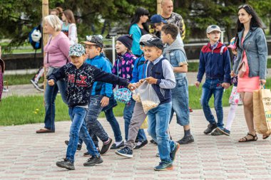 Petropavlovsk, Kazakistan-1 Haziran 2019: Uluslararası Çocuk günü. Şehir sokaklarında okul öğrencileri geçit töreni. Ulusal tatil kıyafetlerinin içinde çocuklar ve ebeveynler. Dans tatil şarkıları.