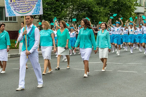 哈萨克斯坦彼得罗巴甫洛夫斯克 2019年6月1日 国际儿童节 学生们的游行队伍穿过城市的街道 孩子和父母穿着国定假日的衣服 跳舞的节日歌曲 — 图库照片