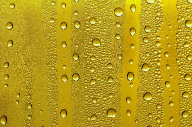 Cam su damlaları, sarı arka plan bira, buğulu arka plan.