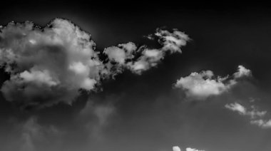 Beyaz bulutların üzerinde karanlık bir gökyüzü, tek renkli.