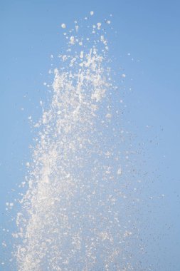 Mavi gökyüzüne karşı Su Çeşmesi sprey. Su sıçramaları odak dışında.