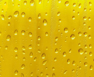 Cam su damlaları, sarı arka plan bira, buğulu arka plan.