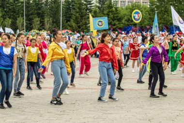 Petropavlovsk, Kazakistan-1 Haziran 2019: Uluslararası Çocuk günü. Şehir sokaklarında okul öğrencileri geçit töreni. Ulusal tatil kıyafetlerinin içinde çocuklar ve ebeveynler. Dans tatil şarkıları.