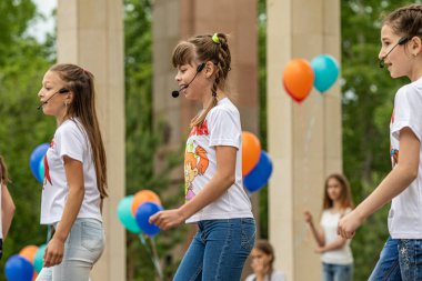 Petropavlovsk, Kazakistan-1 Haziran 2019: Uluslararası Çocuk günü. Şehir sokaklarında okul öğrencileri geçit töreni. Ulusal tatil kıyafetlerinin içinde çocuklar ve ebeveynler. Dans tatil şarkıları.