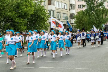 Petropavlovsk, Kazakistan-1 Haziran 2019: Uluslararası Çocuk günü. Şehir sokaklarında okul öğrencileri geçit töreni. Ulusal tatil kıyafetlerinin içinde çocuklar ve ebeveynler. Dans tatil şarkıları.